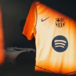 Camisa de time de futebol com qualidade tailandesa 1.1 em destaque exibindo detalhes das costuras e do escudo bordado.