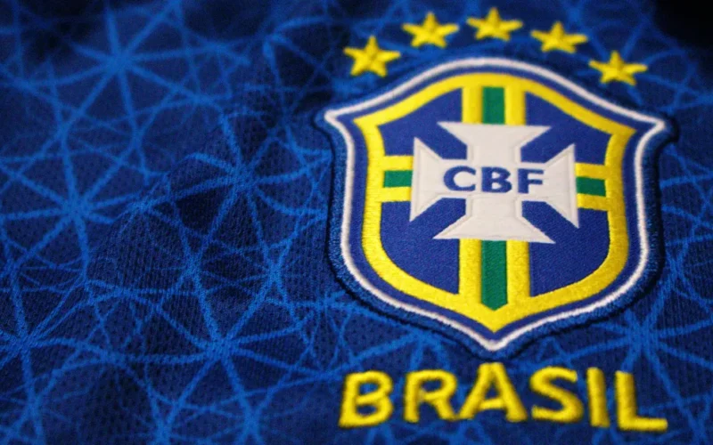 Renderização conceitual da nova camisa azul da seleção brasileira para a Copa do Mundo de 2026, com detalhes dourados e escudo da CBF.