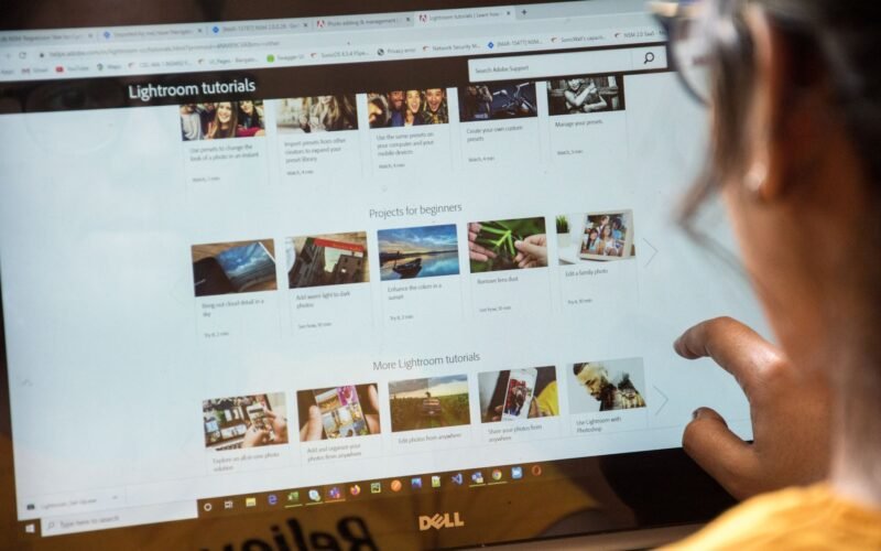 Jovem editor de vídeo trabalhando em notebook com software de edição, mostrando um certificado digital.