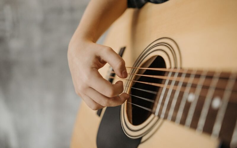 Mão esquerda de um violonista fazendo uma pestana perfeita em um violão de cordas de nylon, sem trastejar e com expressão de conforto.