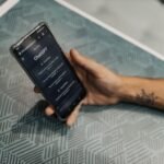 Músico utilizando o aplicativo SmartCifra do Erick França em um tablet durante uma apresentação ao vivo, com partituras digitais e acordes.