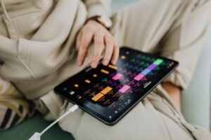 Músico tocando violão em palco, com um tablet em um suporte exibindo cifras em rolagem automática e um pedal bluetooth no chão.