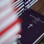 Mãos digitando em um tablet com partituras e um calendário de ensaios ao fundo, simbolizando organização e tecnologia no ministério de louvor.