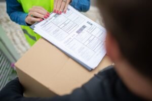 Pessoa analisando documentos de segurança do trabalho em um escritório, com logo da NR1 ao fundo e equipe de segurança.