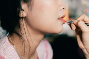 Profissional realizando procedimento de micropigmentação labial em cliente com dermógrafo de precisão