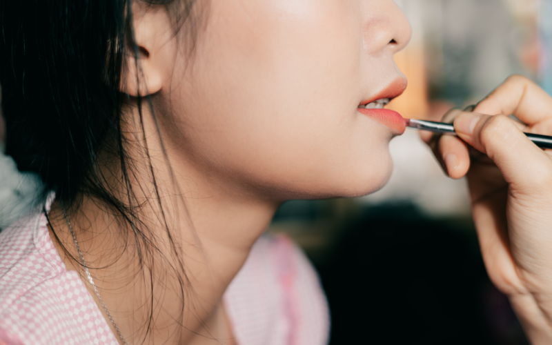 Profissional realizando procedimento de micropigmentação labial em cliente com dermógrafo de precisão